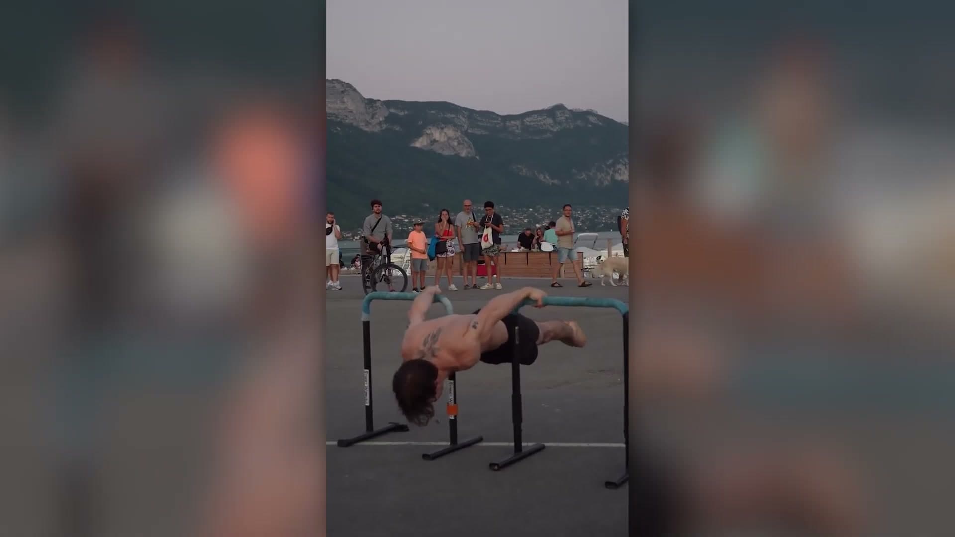 Straddle planche demonstration outdoors on parallel bars